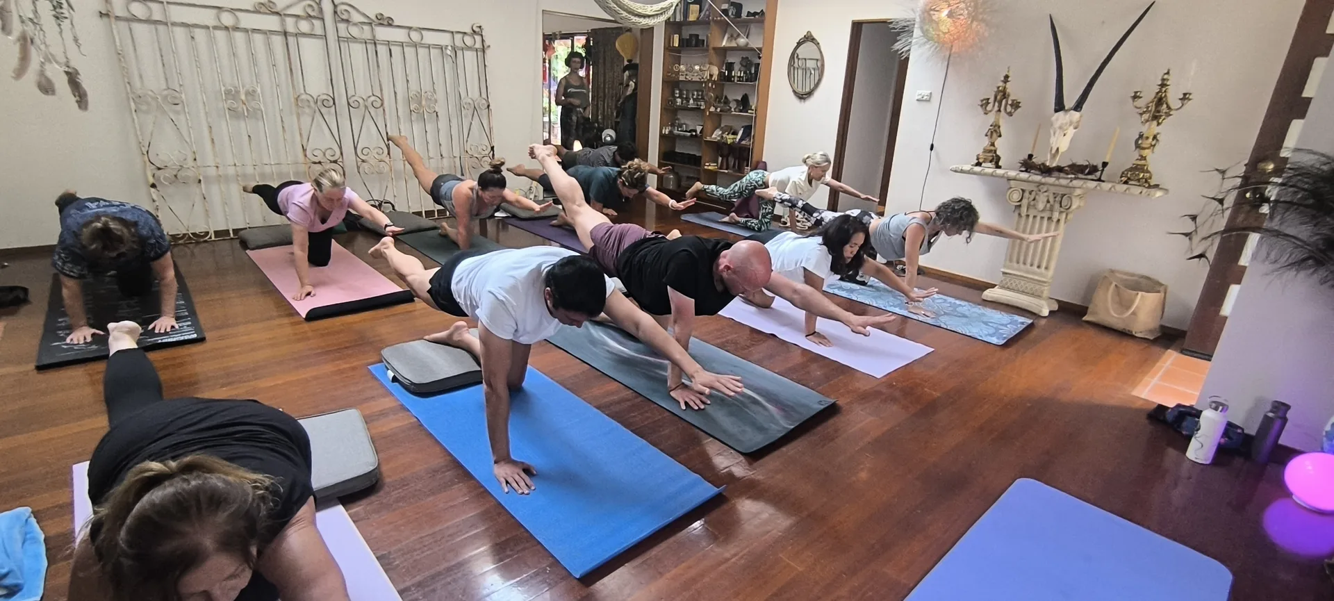 Instructor adjusting student alignment during yoga session