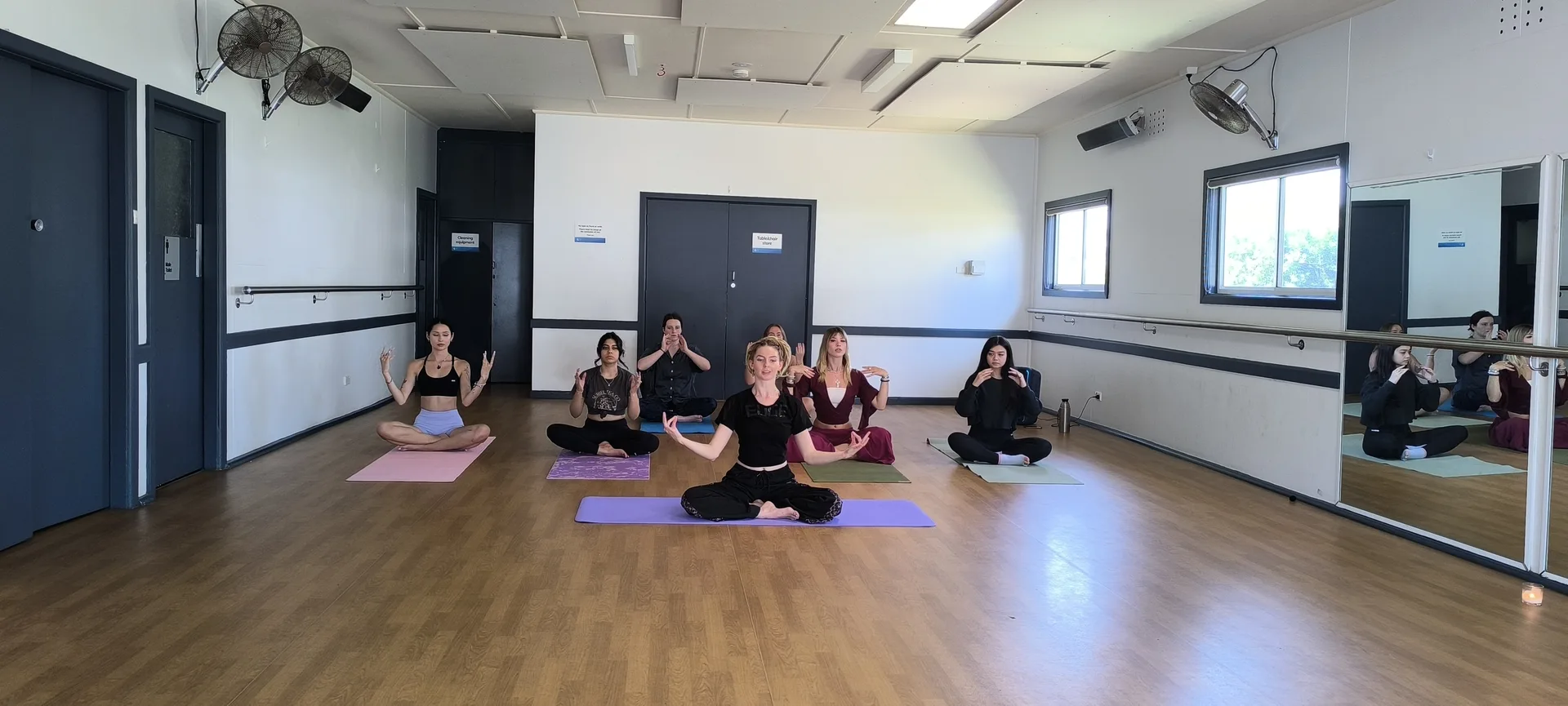 Tranquil yoga studio atmosphere with community members in relaxation pose